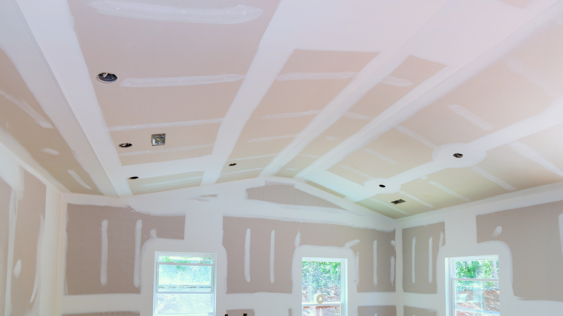 Freshly plastered and taped ceiling and walls in a new room, ready for decoration
