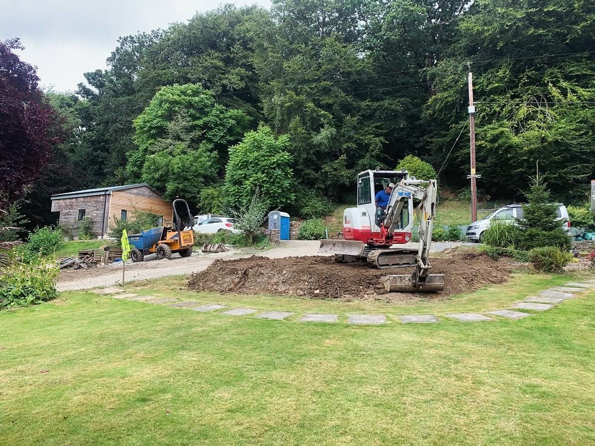 Mini excavator stripping ground for groundworks in a residential garden