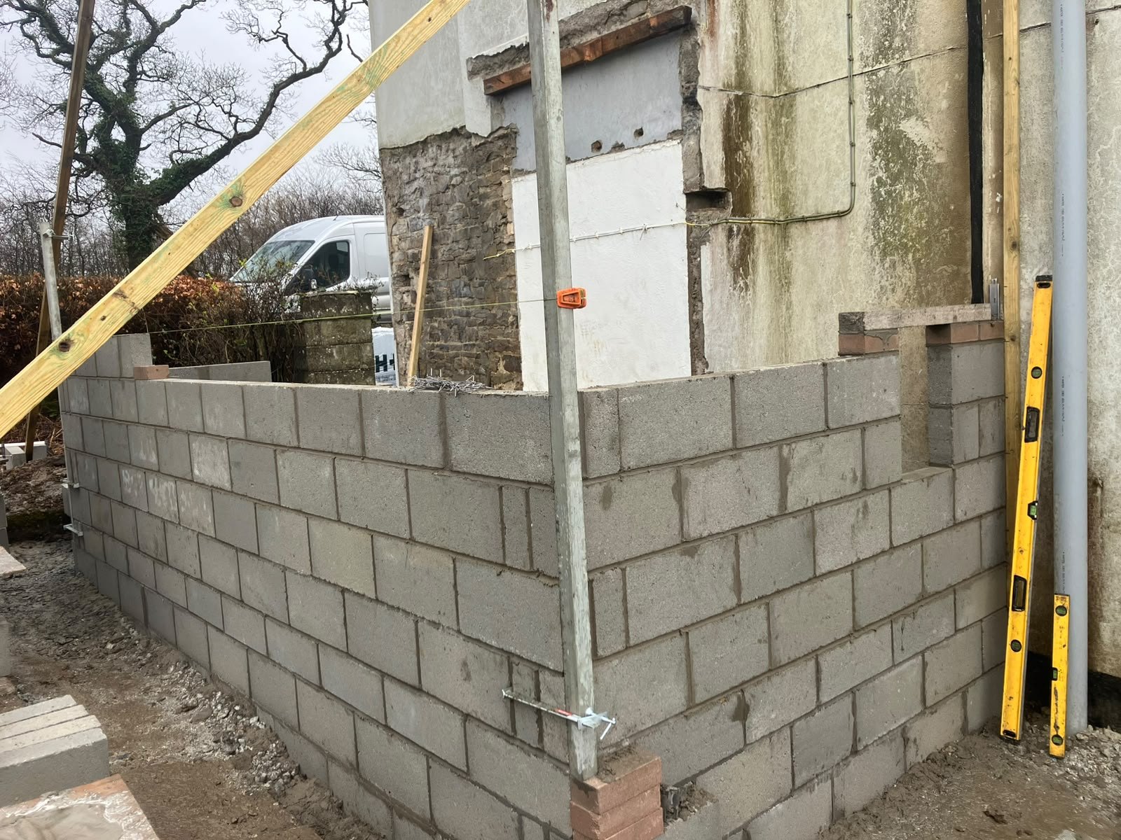 Extension under construction: blockwork walls being built alongside an existing stone wall