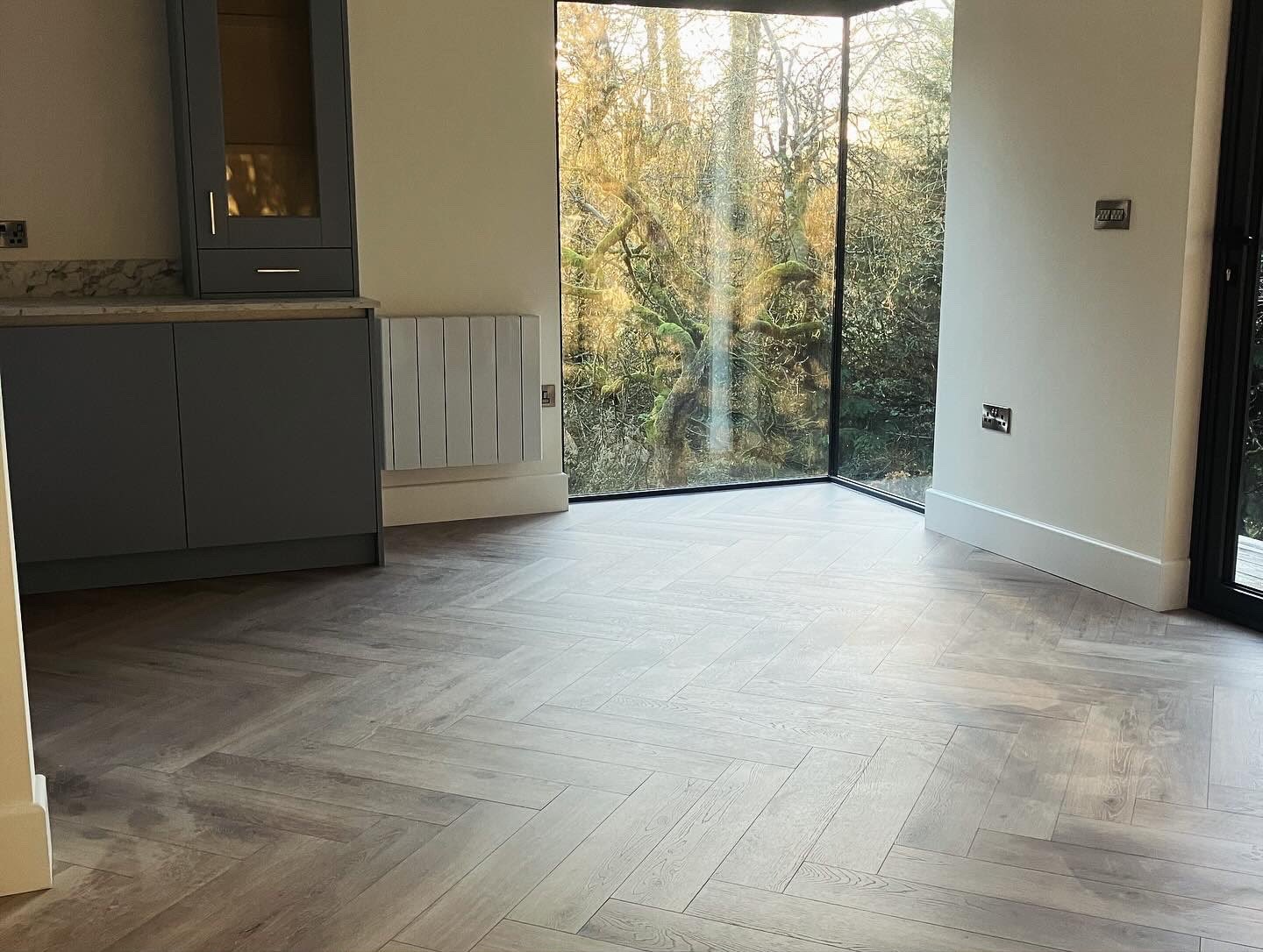 Floor-to-ceiling picture window in a new extension overlooking woodland