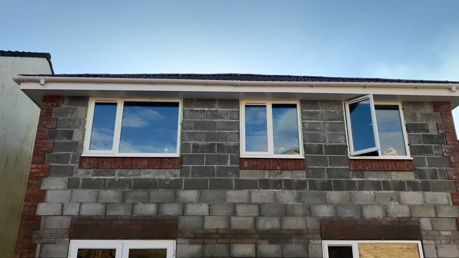 New windows installed into blockwork walls on an extension under a slate roof