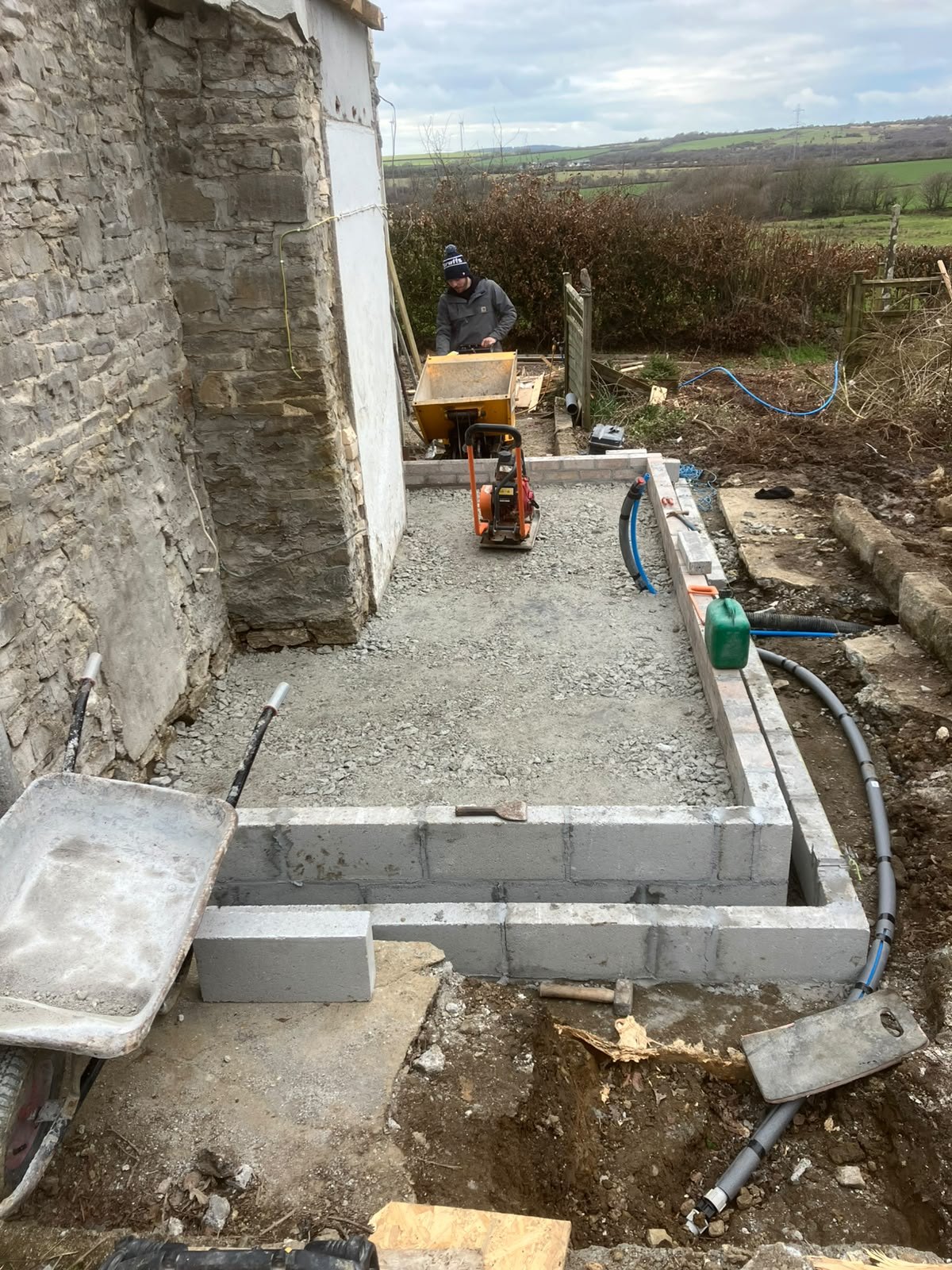 Compacting the hardcore base inside new foundations with a plate compactor