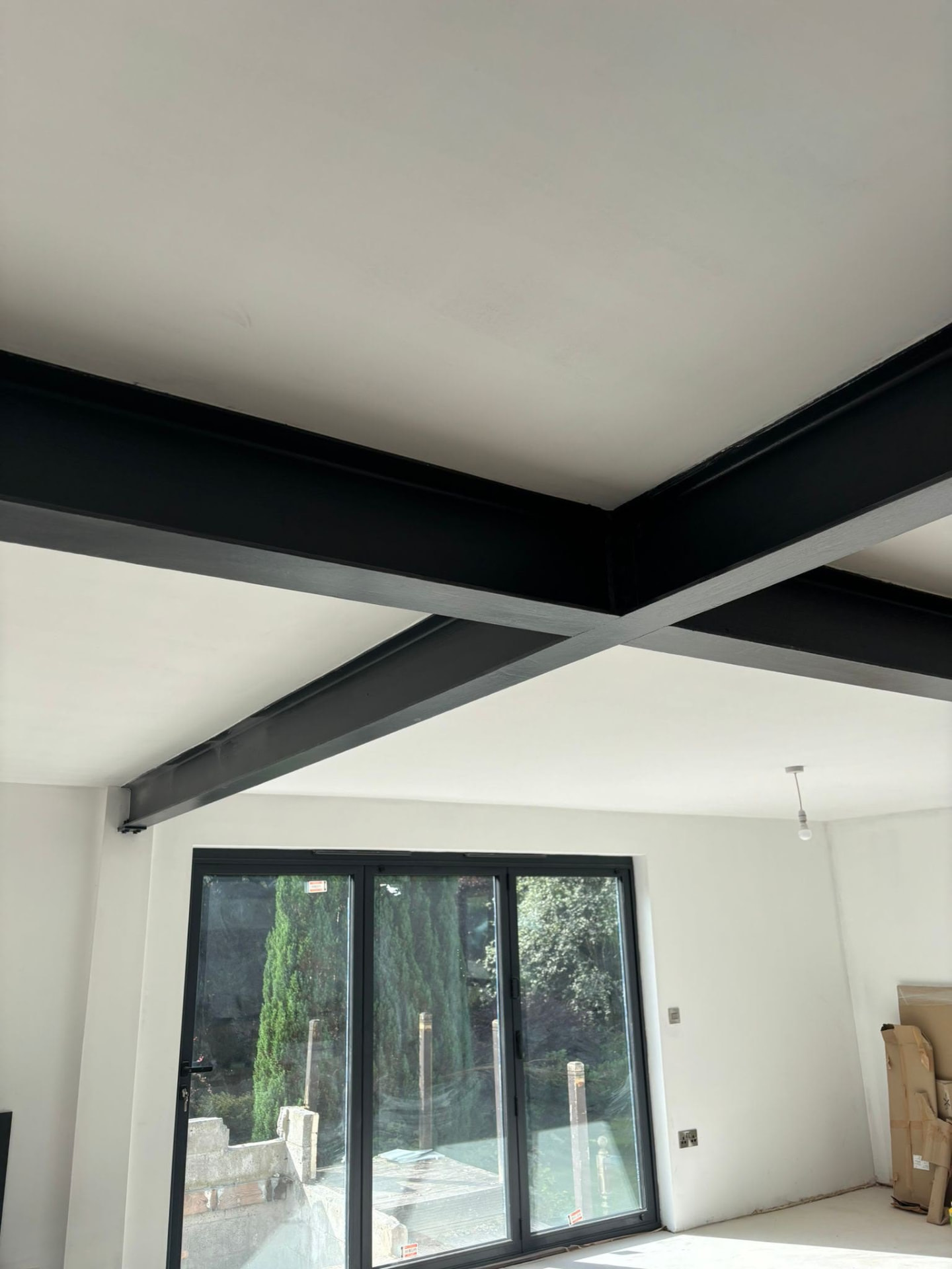 Painted steel goalpost frame supporting the ceiling after a load-bearing wall removal