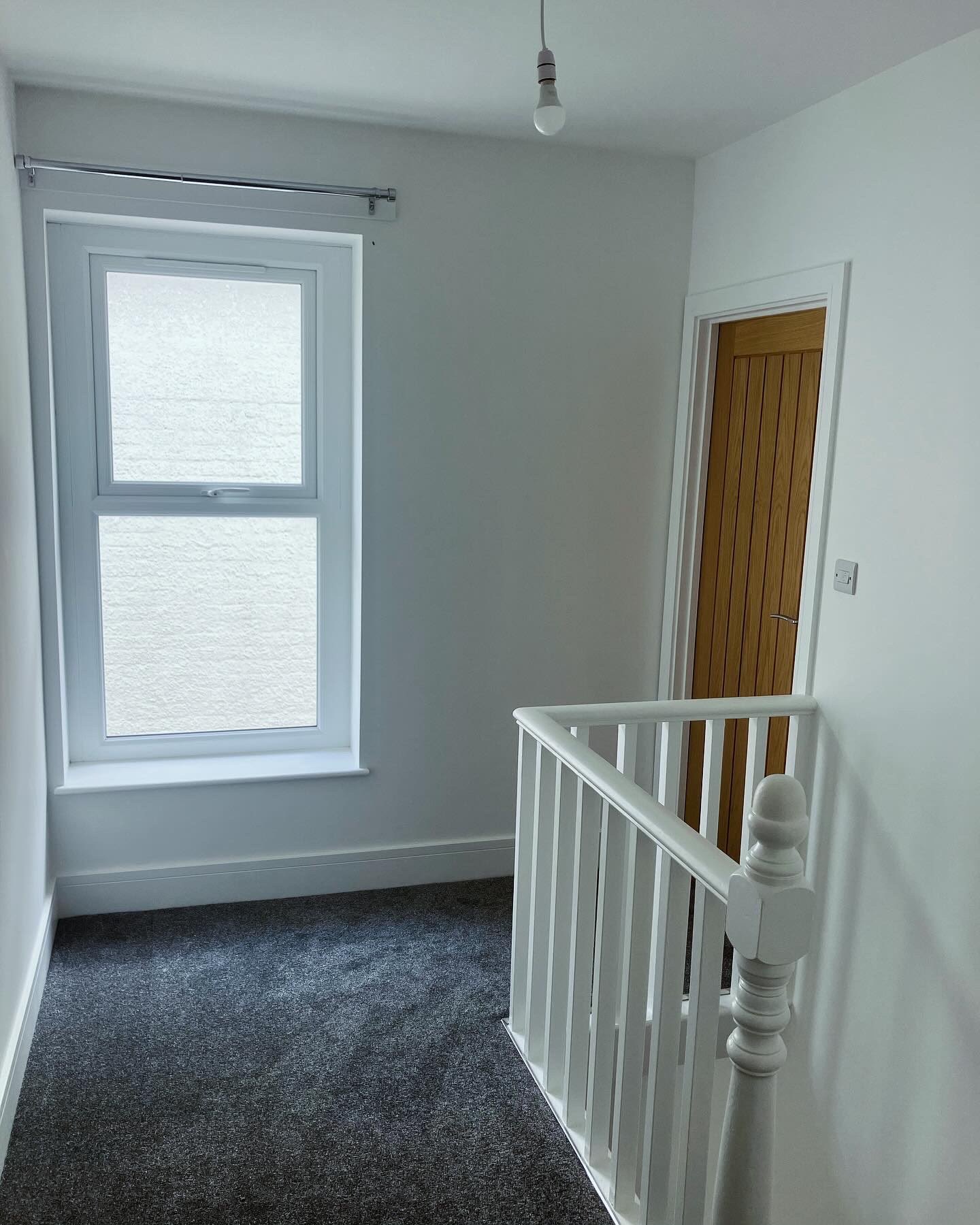 Refurbished landing with a new balustrade, oak door and fresh carpet