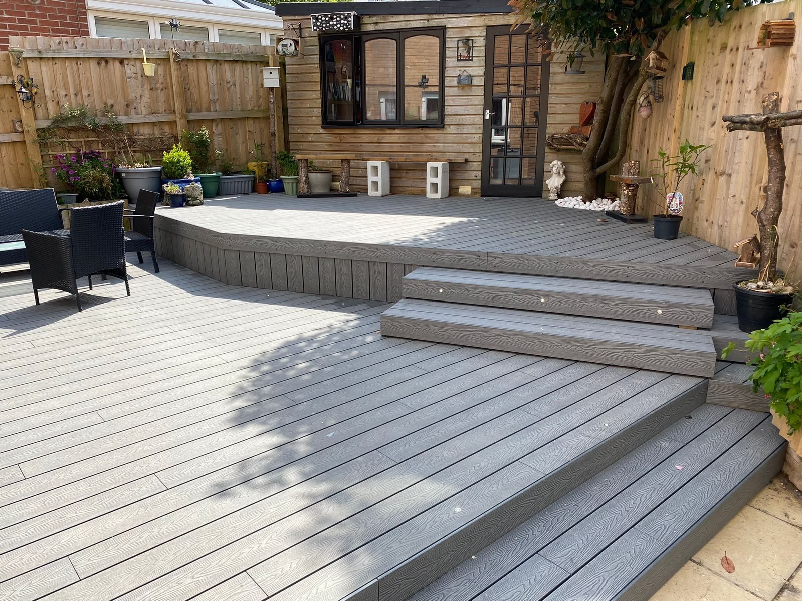 Composite decking with integrated lighting and wide steps leading up to a garden room