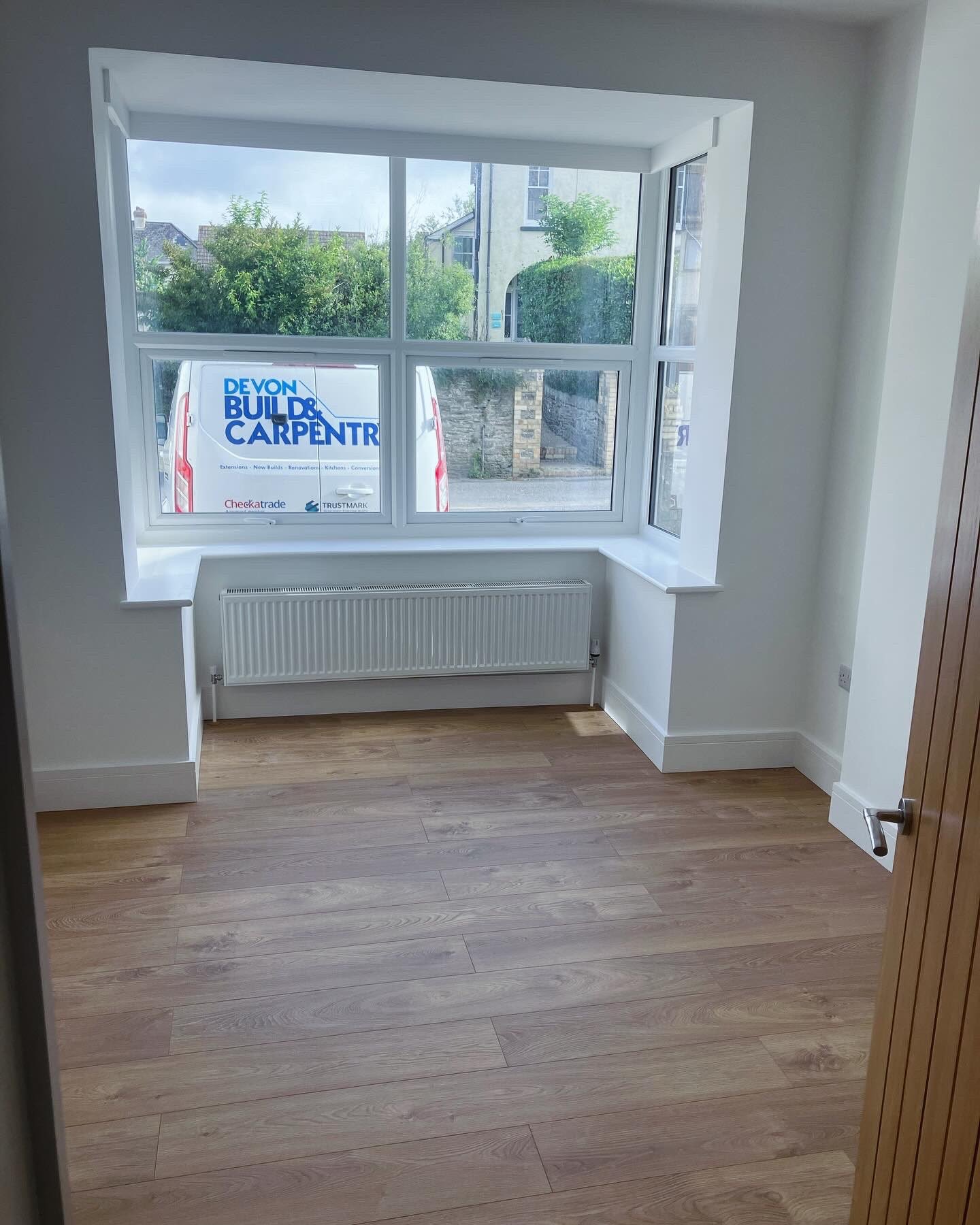Renovated front room with a rebuilt bay window, new sill, radiator and laminate flooring