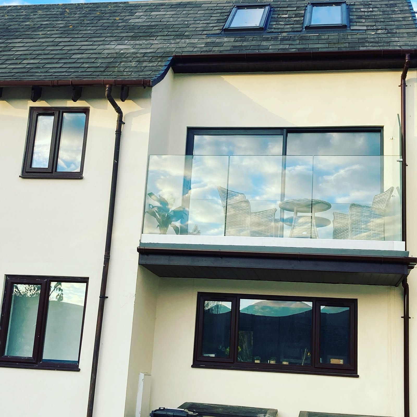 Extension balcony with frameless glass balustrade overlooking the garden